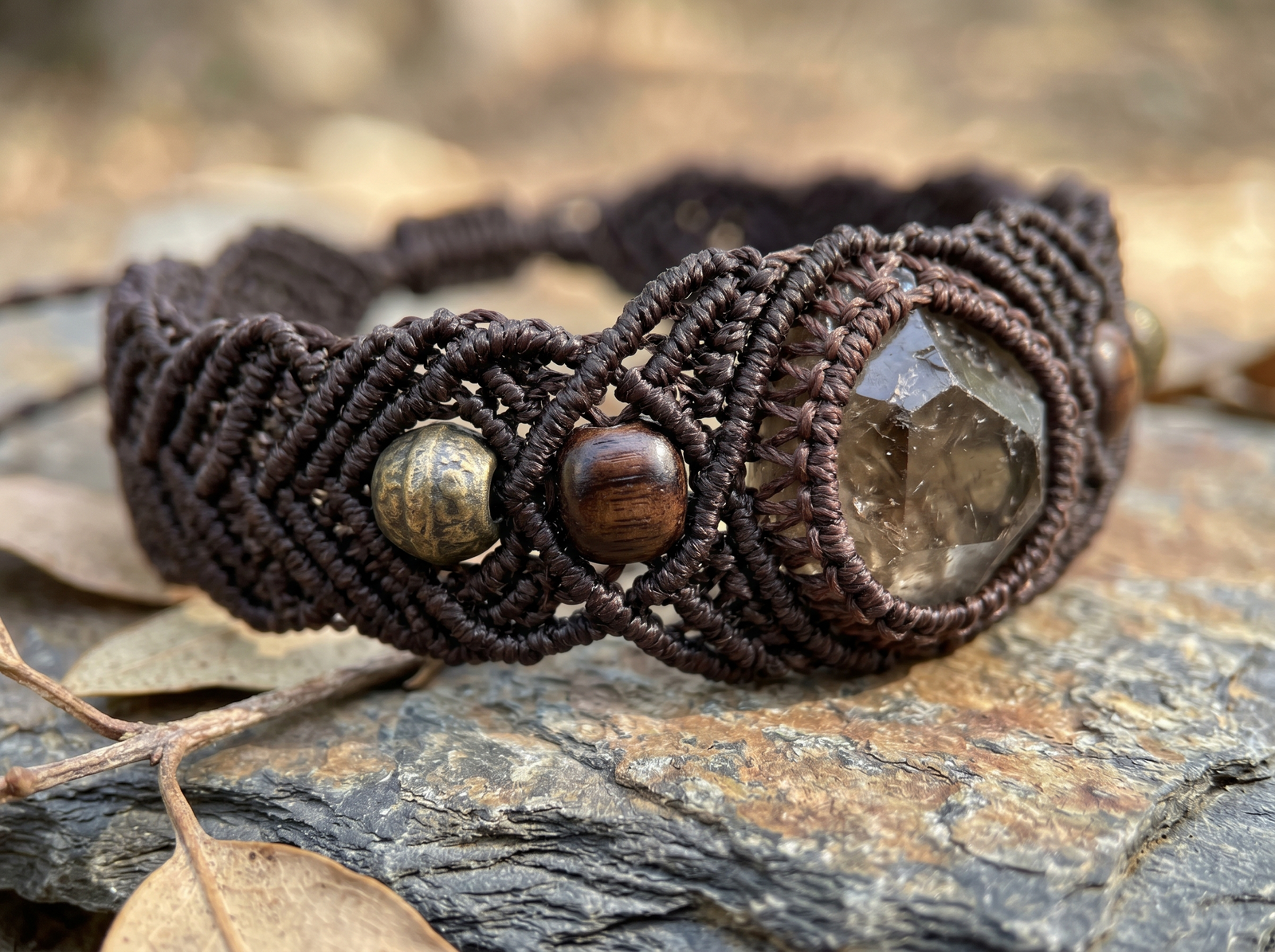Macro view of a handcrafted crystal macrame bracelet demonstrating the 7:3:1 artisan color ratio with bronze and wood accents.