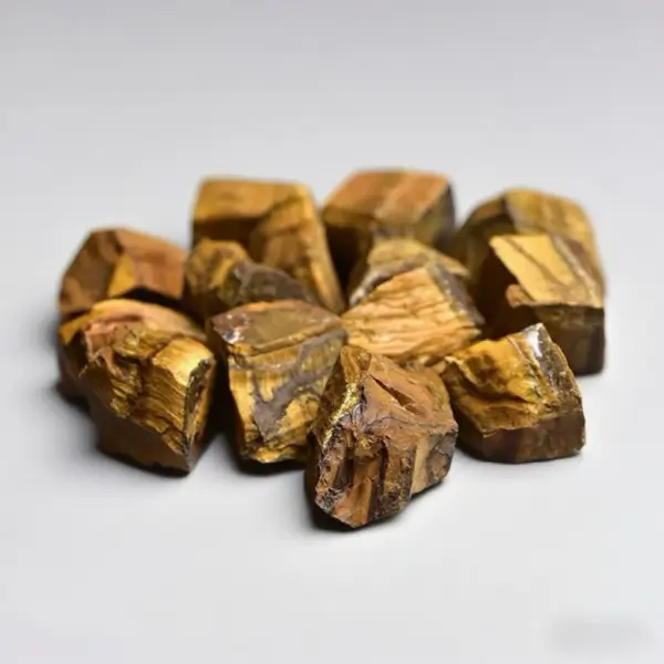 Close-up of ethically mined Tiger Eye Raw Stones showcasing their distinctive golden-brown bands and chatoyancy effect. Perfect for grounding energy, career success, and bohemian home decor.