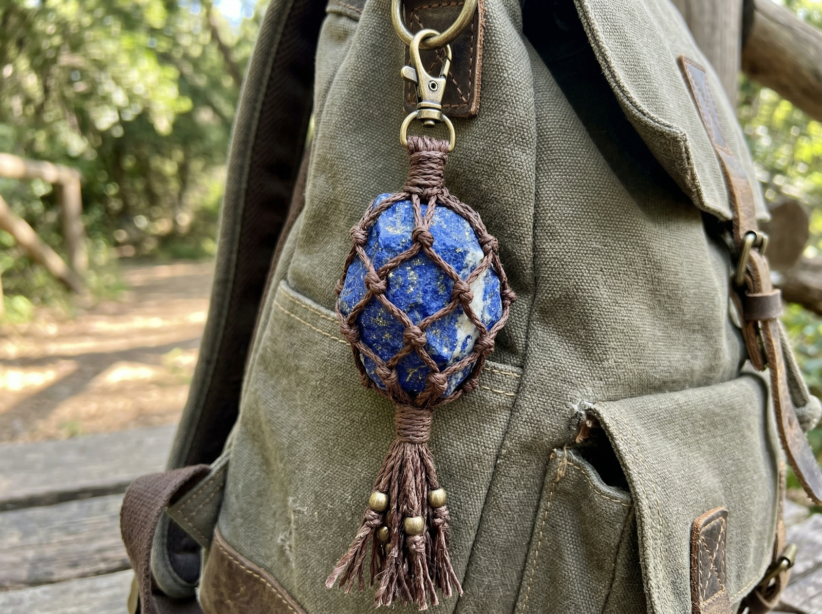 A handmade macrame bag charm with a raw Lapis Lazuli stone secured in a protective hand-knotted pouch.