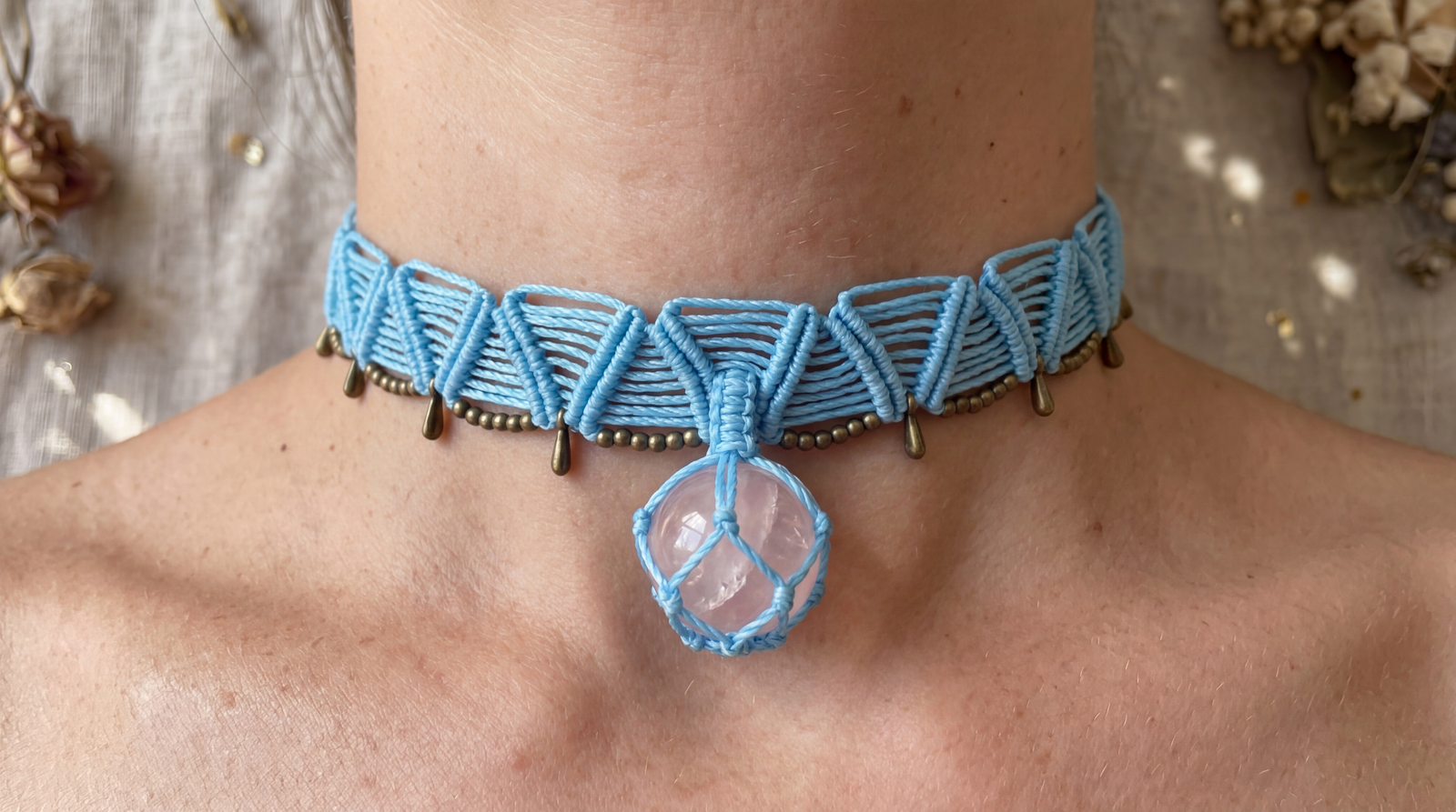 Round rose quartz bead wrapped in vibrant light blue macrame snake knots worn as a choker.