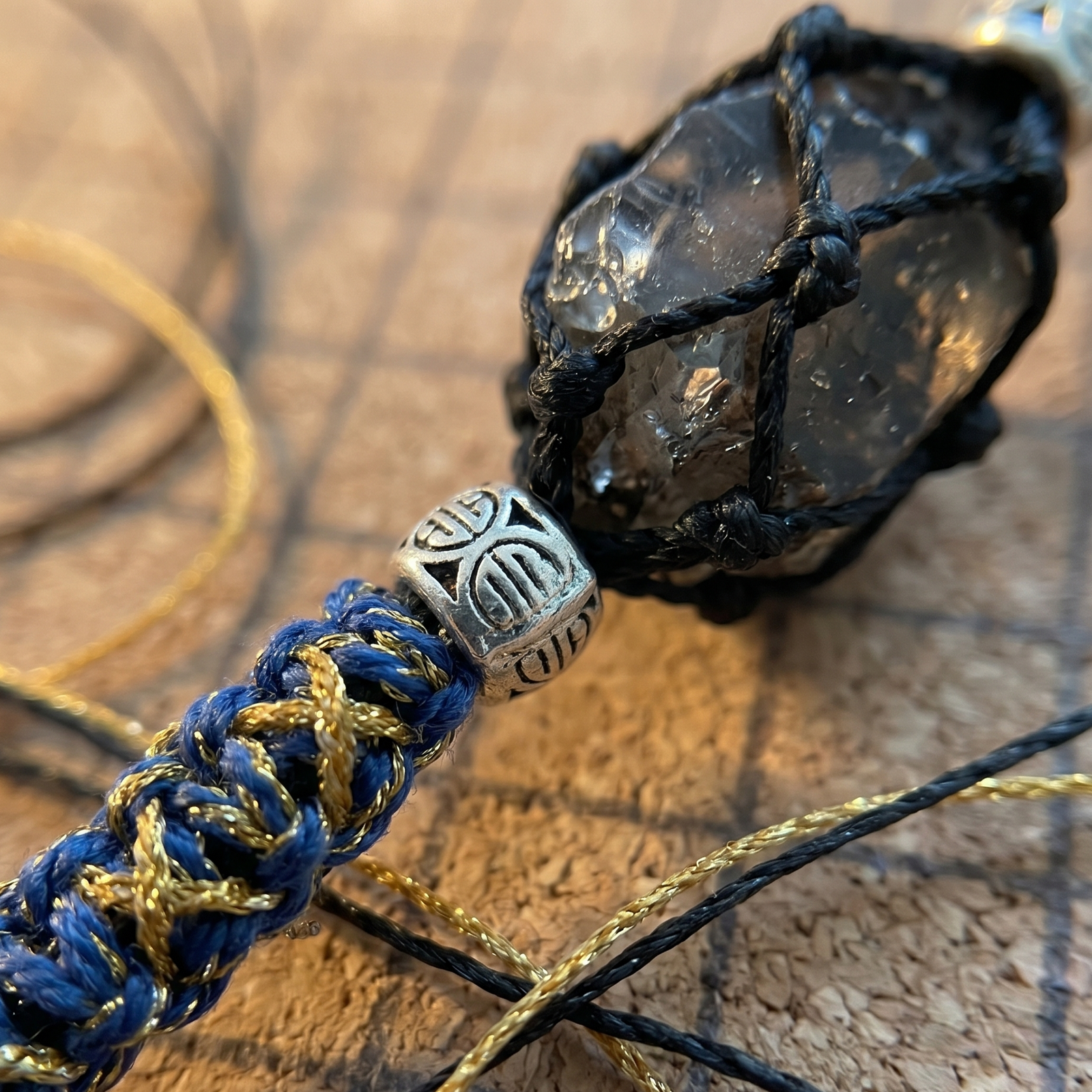 Extreme macro close up showing the detailed black net macrame wrapping around a clear raw Herkimer Diamond.